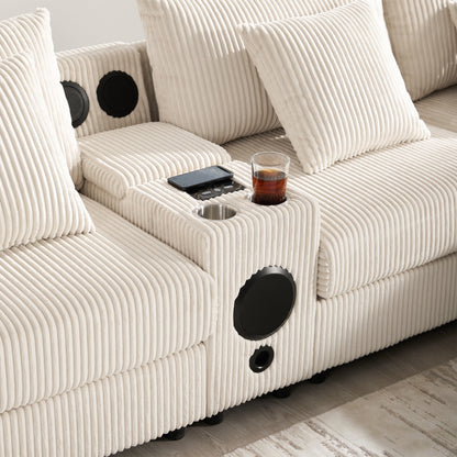 Canapé d'angle en velours côtelé avec haut-parleurs Bluetooth, chargeur USB, porte-gobelets, rangement, pouf, assise profonde et large.