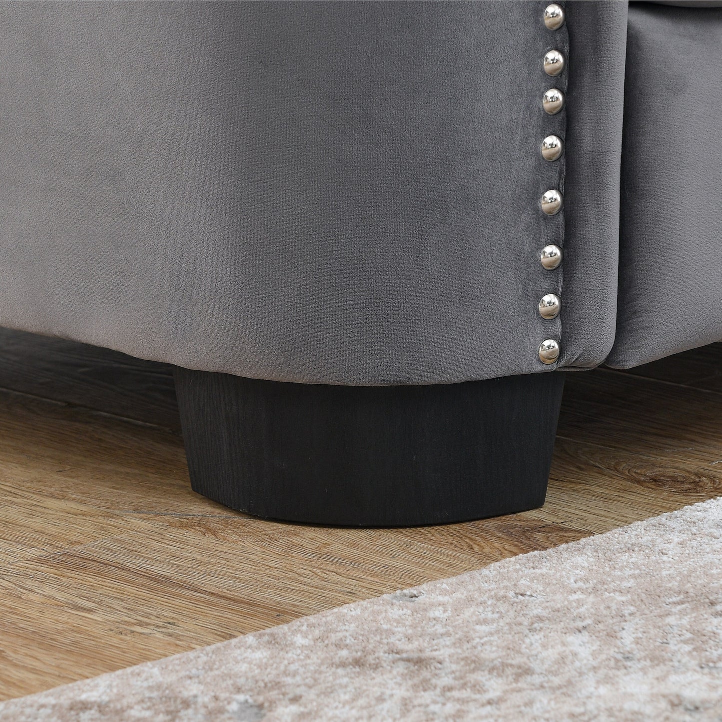 Canapé 2 places gris moderne en velours de 150 cm avec dossier capitonné et accoudoirs à clous.