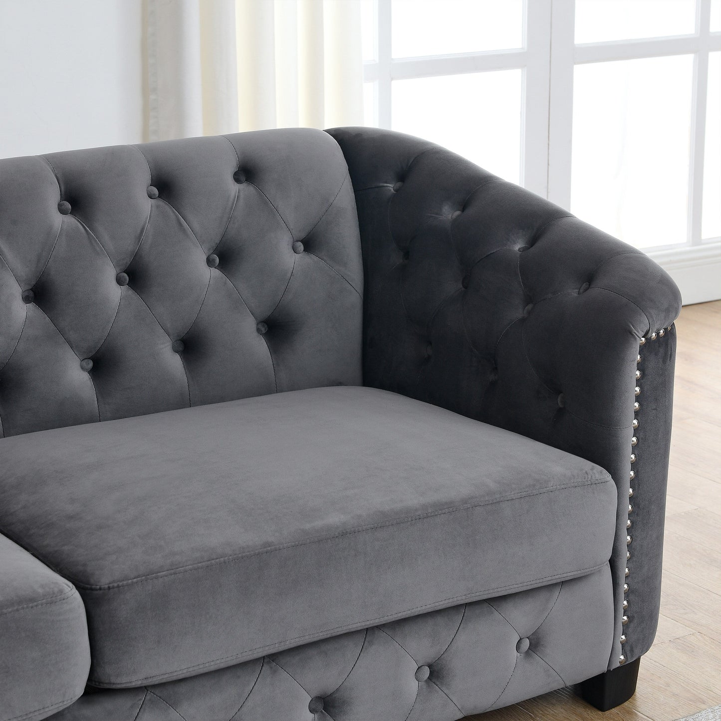 Canapé 2 places gris moderne en velours de 150 cm avec dossier capitonné et accoudoirs à clous.