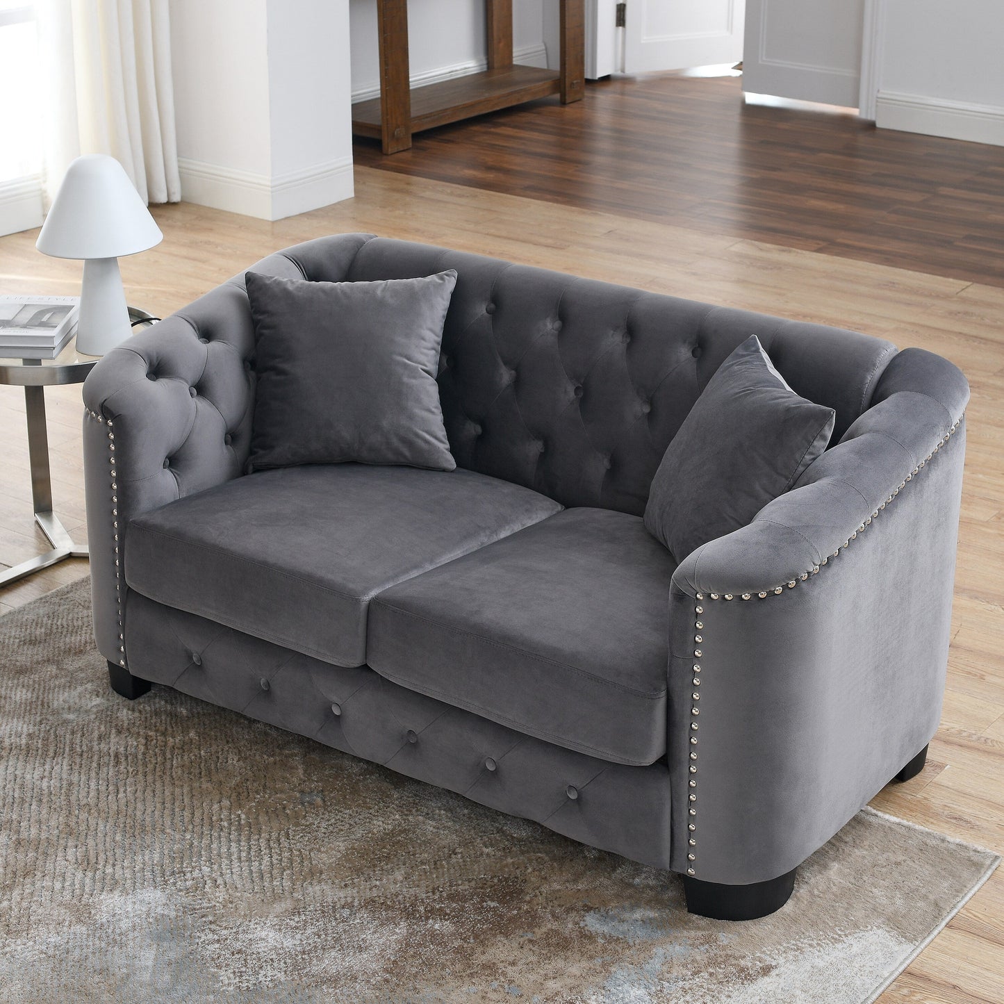 Canapé 2 places gris moderne en velours de 150 cm avec dossier capitonné et accoudoirs à clous.