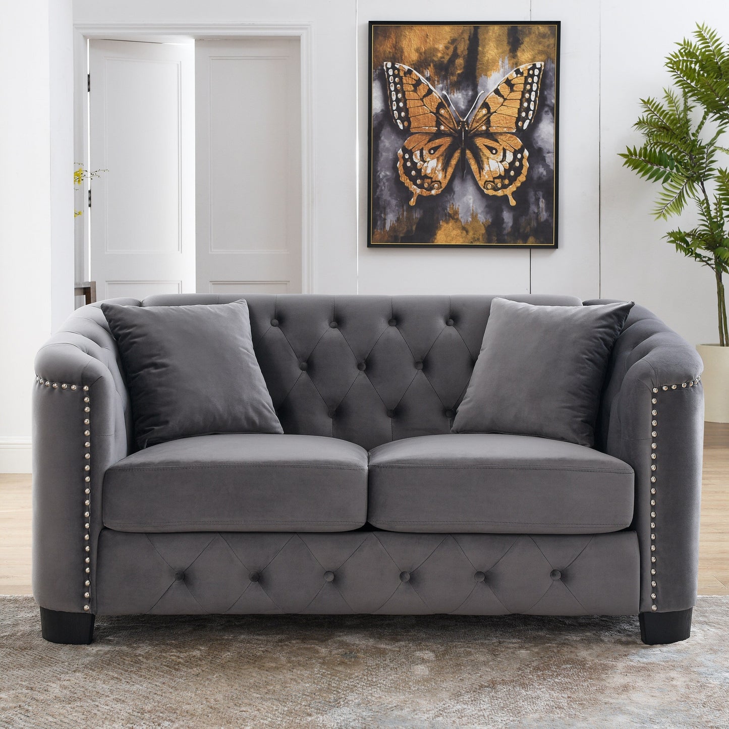 Canapé 2 places gris moderne en velours de 150 cm avec dossier capitonné et accoudoirs à clous.